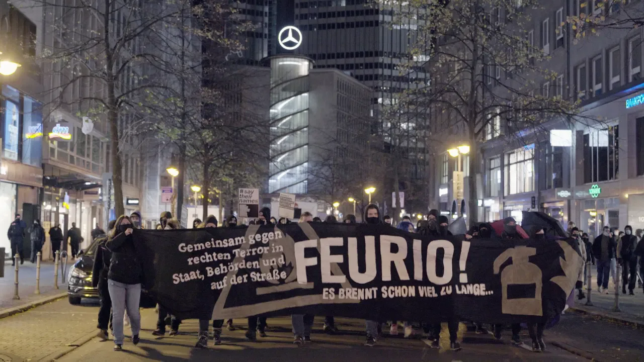 Demonstrationszug in Frankfurt. Es wird ein Transparent getragen auf dem steht: 